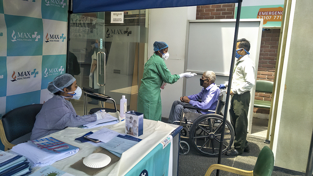 A patient is screened for COVID-19 before being allowed into the eye hospital.