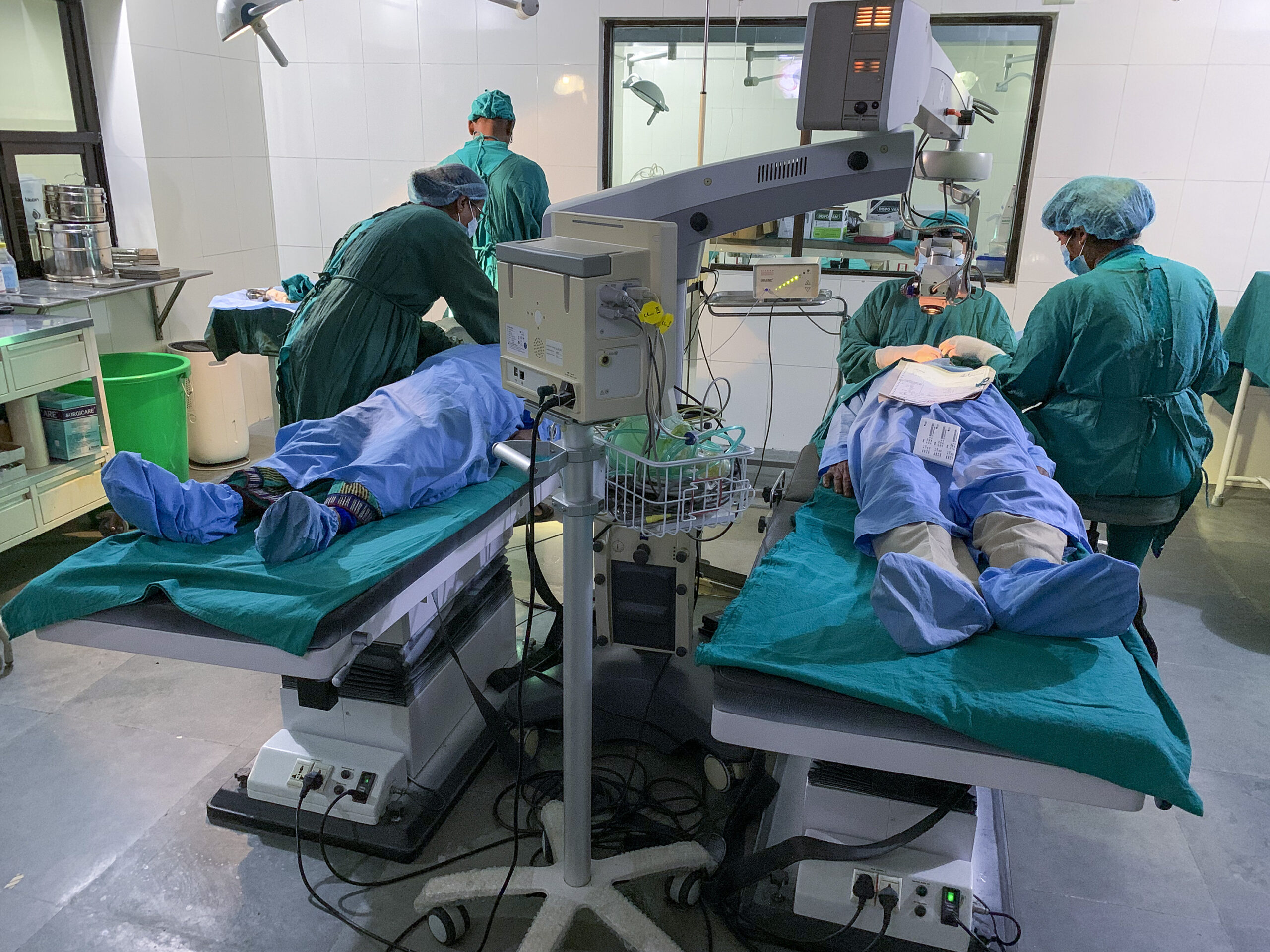 The patient on the left is being prepared for surgery while the surgeon is busy with the patient on the right, Nepal.